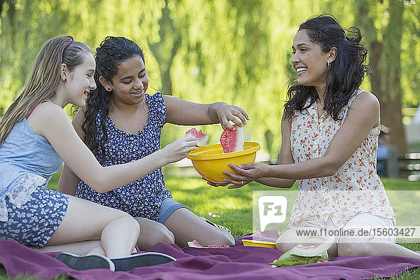 Glückliche hispanische Familie beim Picknick im Park  die Mädchen mit Zahnspange