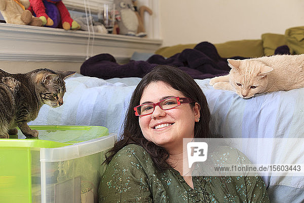 Frau mit Asperger-Syndrom spielt mit ihren Hauskatzen