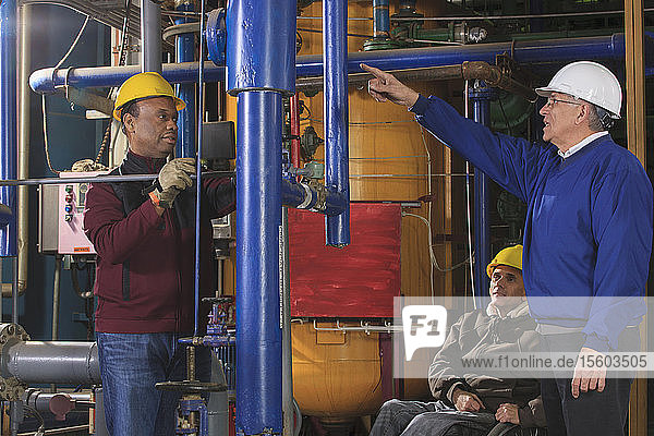 Power plant engineers one with spinal cord injury inspecting demineralization pipes