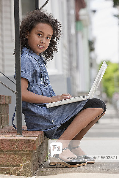 Porträt eines hispanischen Mädchens  das einen Laptop benutzt