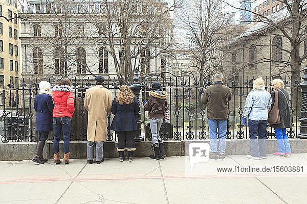 Tourists looking at The King's Chapel Burying Ground historic site with Old Boston City Hall  Boston  Suffolk County  Massachusetts  USA