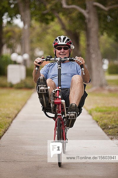 Man riding a recumbent bicycle in a park