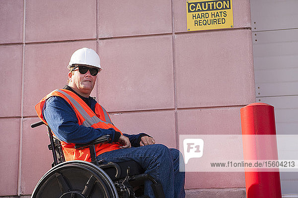 Gebäudetechniker im Rollstuhl im Bereich des Schutzhelms