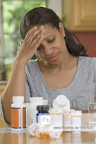 Hispanische Frau  die unter Kopfschmerzen leidet