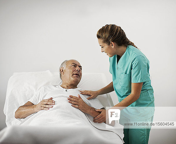 Man in hospital receiving a visit from his nurse
