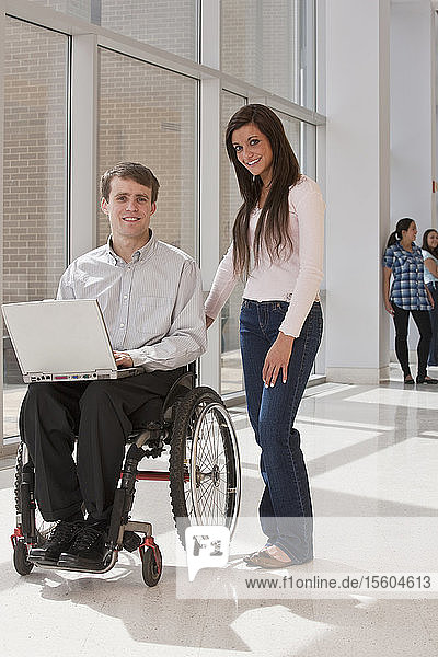 Lehrerin mit Rückenmarksverletzung im Rollstuhl mit ihren Schülern im Hintergrund