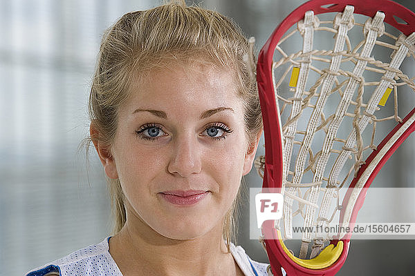 Porträt einer Frau mit einem Lacrosse-Schläger.