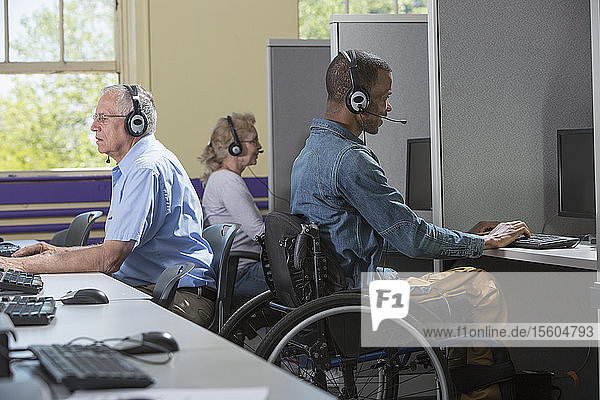 Mann mit Spinaler Meningitis im Rollstuhl arbeitet in einem Call Center