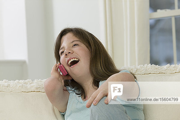 Teenage girl with birth defect talking on a mobile phone
