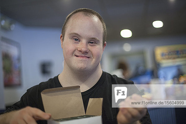 Porträt eines glücklichen Kellners mit Down-Syndrom bei der Vorbereitung in einem Restaurant