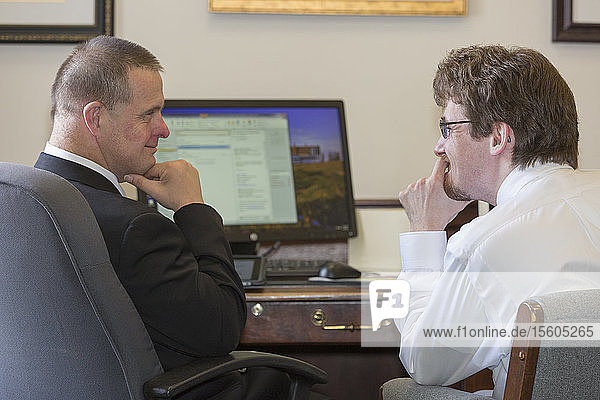 Mann mit Down-Syndrom im Gespräch mit einem Mitarbeiter im State Capitol in seinem Büro