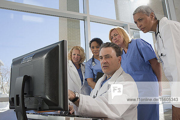 Doctors and nurses consulting on a computer in hospital