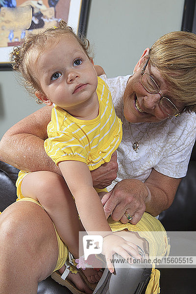 Grandmother with a prosthetic leg playing with her granddaughter