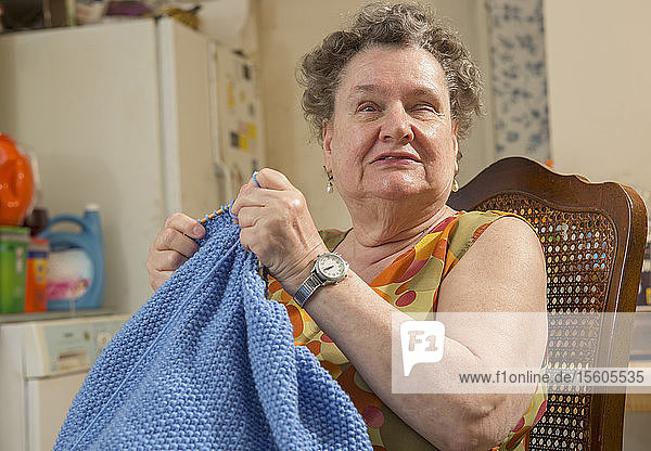 Blinde Seniorin strickt zu Hause eine warme Decke