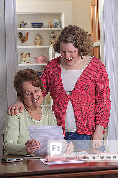 Mutter hilft Tochter mit Autismus beim Ausfüllen von Bewerbungen
