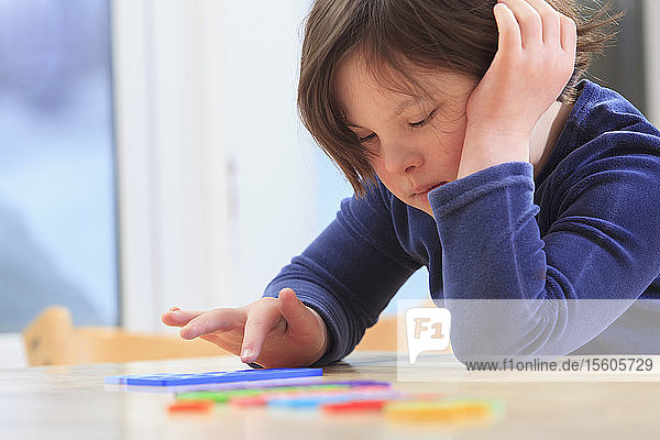 Little girl with Down Syndrome playing a learning game