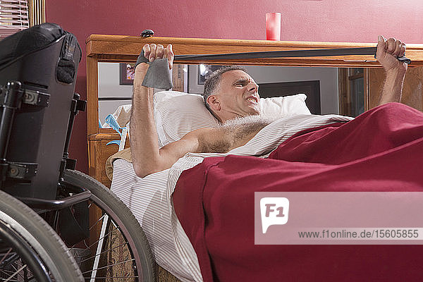 Man with spinal cord injury exercising in the bed