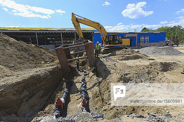 Bagger und Grabenschutz für Bauarbeiter bei der Verlegung von Wasserleitungen