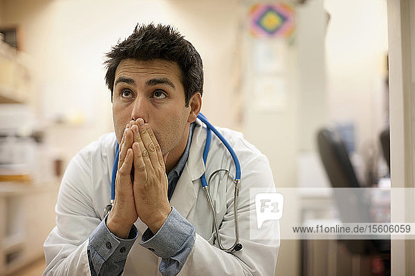 Ein besorgter Arzt sitzt in seinem Büro