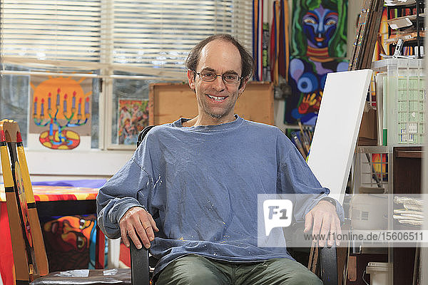 Man with Asperger's sitting in his art studio