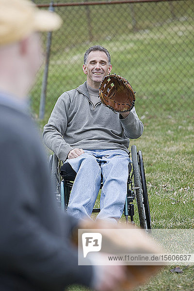 Behinderter Mann spielt Baseball mit seinem Sohn