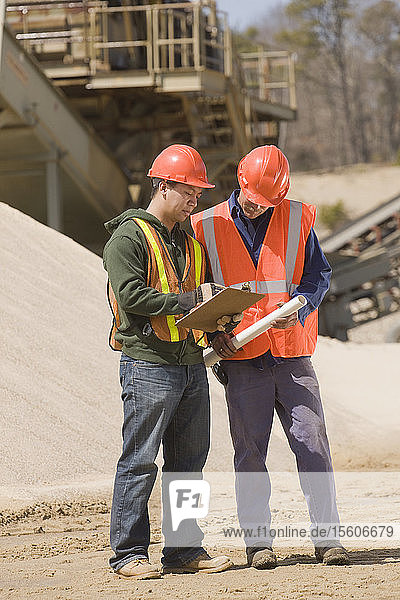 Zwei Ingenieure diskutieren in einem Schotter- und Asphaltwerk