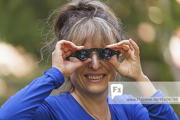 Woman with visual impairment using special glasses to see in park