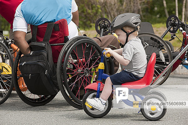 Man with spinal cord injury and boy with joint problems preparing for accessible bike race