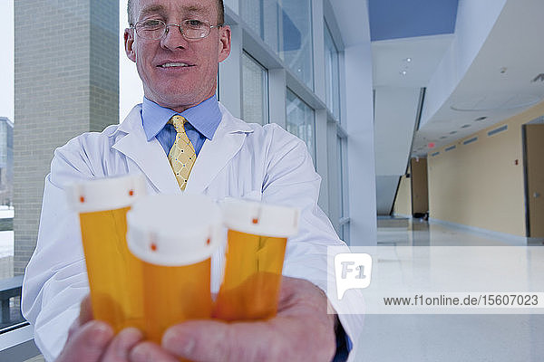 Male pharmacist checking pill bottles
