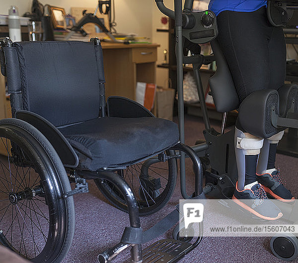Eine Frau mit einer Rückenmarksverletzung setzt sich an ihren Schreibtisch  damit sie aufstehen kann