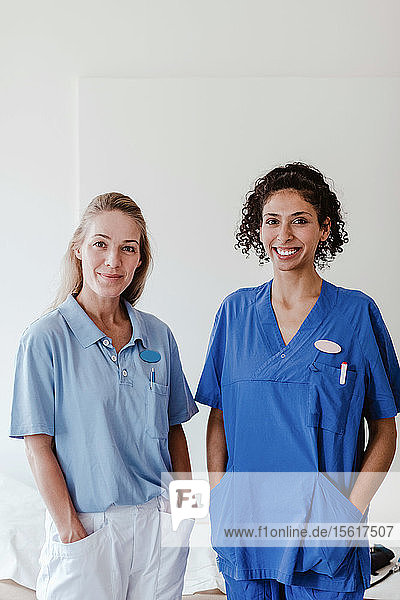 Porträt einer selbstbewussten Krankenschwester und Ärztin  die im Krankenhaus an einer weißen Wand steht