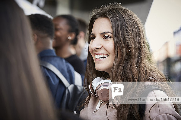 Lächelnde Teenagerin schaut weg  während sie in der Stadt steht