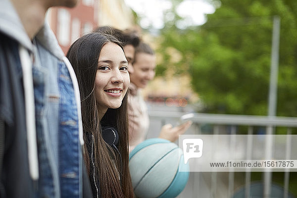 Porträt eines lächelnden Teenagers der mit Freunden spazieren geht
