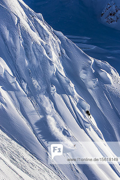 Der Profi-Snowboarder Robin Van Gyn fährt an einem sonnigen Tag mit dem Snowboard in Haines  Alaska  durch frischen Pulverschnee.