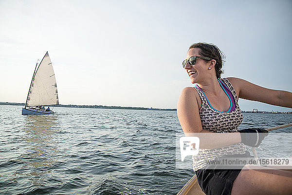 Lächelnde Frau genießt das Segeln in der Narragansett Bay