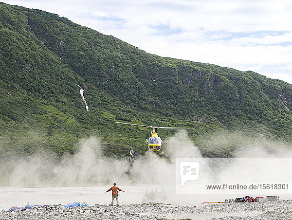 Flößer hilft Hubschrauber  eine Ladung Flöße sicher auf einer Sandbank abzuwerfen