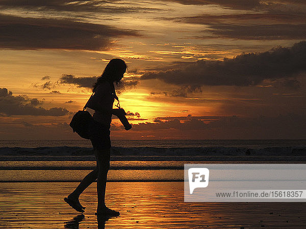 Fotograf Frau zu Fuß in der Nähe von Meer. Kuta Strand Ubud Indonesien