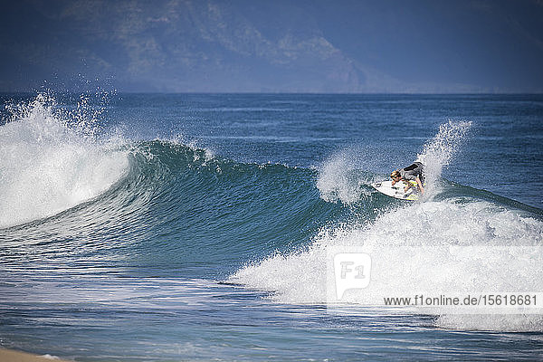 Distant view of man in wetsuit surfing in sea