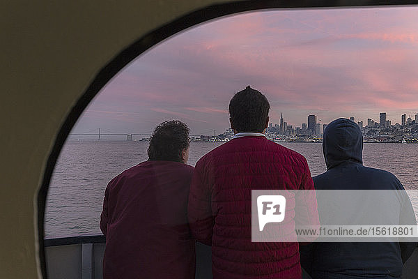Rückansicht von drei Passagieren auf der Fähre von Sausalito nach San Francisco mit Blick auf die Stadt  Kalifornien  USA
