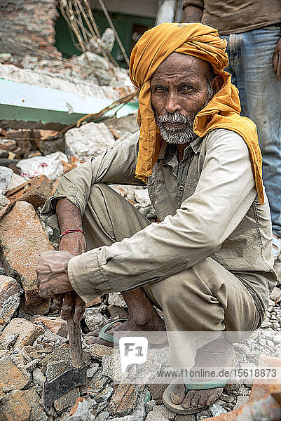 Ein Arbeiter  der Ziegelsteine aus den Trümmern des Erdbebens in Kathmandu  Nepal  holt