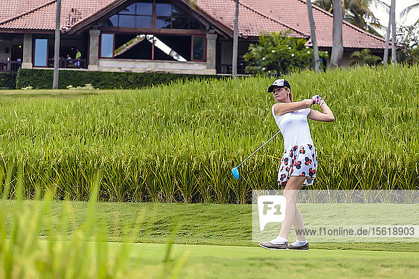 Young woman playing golf  Bali  Indonesia