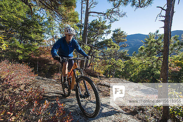 Mountain Biker Riding On The Bare Granite Slabs Of The Whitehorse Ledge  New Hampshire