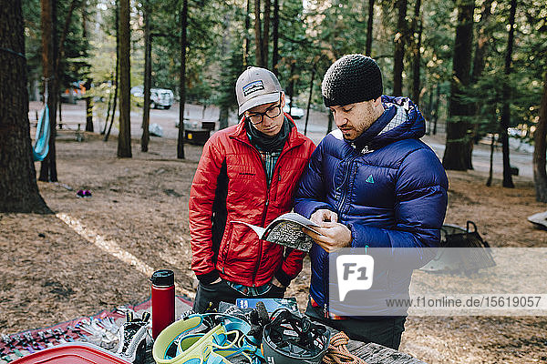 Two climbers looking over the guide book at a campground in Yosemite.