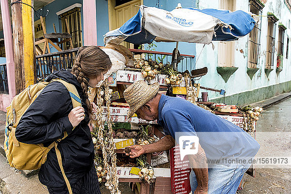 Frau kauft Gemüse von einem einheimischen Mann  der einen Verkaufsstand im Freien betreibt  Baracoa  Kuba