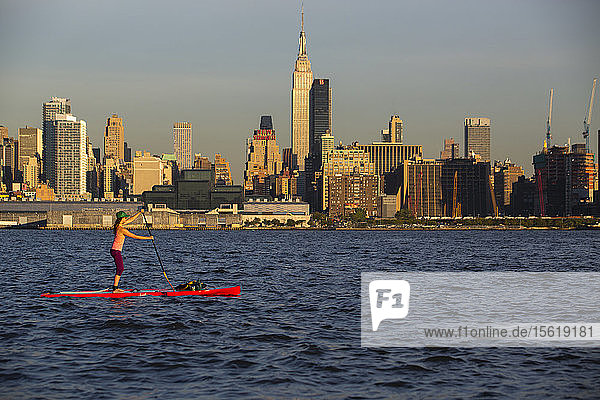 Woman Paddleboarding On Hudson River In Manhattan  New York City  Usa
