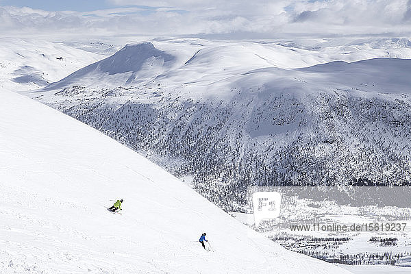 Zwei Skifahrer fahren einen Berg im Skigebiet von Myrkdalen in Fjord  Norwegen  hinunter