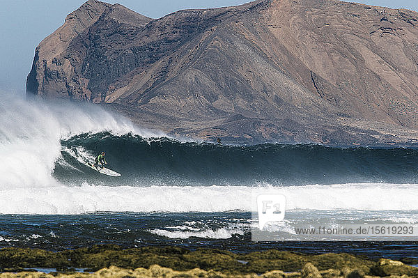 Big-Wave-Surferin Vilayta surft auf einer Welle auf einem Stand Up Paddle Board vor einer wunderschönen Kulisse