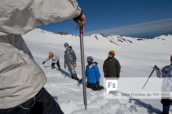 Jungen im Alter von 13 bis 17 Jahren von der Venturing Crew 191 aus Glendora  Kalifornien  setzen ein Jahr Training in die Praxis um  als sie versuchen  den Gipfel des Mount Shasta über die Avalanche Gulch-Route im Shasta Trinity National Forest in Nordkalifornien zu erreichen. Der Mount Shasta ist ein massiver  vergletscherter Vulkan und mit 14.179 Fuß der zweithöchste Gipfel in der Cascade Range und der fünfthöchste in Kalifornien; er ist mit keinem anderen Gipfel verbunden und erhebt sich abrupt 10.000 Fuß über das umliegende Gelände. Die Pfadfinder der Venturing Crew 191 (Venturing Crews sind ein Zweig der Pfadfinder  der sich auf abenteuerliche Aktivitäten konzentriert) hatten sich ein Jahr lang auf ihre Besteigung des Mount Shasta vorbereitet. Dies war ihre erste Erfahrung mit dem Klettern in steilem Schnee  und sie wurden bei ihrem Aufstieg von Führern der SWS Mountain Guides unterstützt. Die Jungen der Venturing Crew 191 (von links nach rechts: Tristan Rodriguez  Josh Kolbach  Morgan Howlett und Dillon Travis) lernen von SWS-Bergführer Casey Hurden (mit dem Eispickel in der Hand)  wie sie ihre Eispickel halten und benutzen können  und zwar an einem Hang direkt unterhalb ihres Hochlagers auf etwa 10.000 Fuß. Von diesem Lager aus wird die Crew vor der Morgendämmerung aufbrechen und versuchen  den Gipfel des Mount Shasta über die Avalanche Gulch Route zu erreichen  Shasta Trinity National Forest  Kalifornien