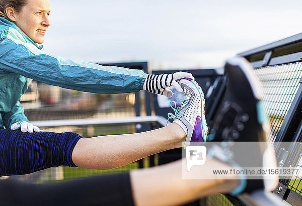 Zwei Läuferinnen in Sportkleidung dehnen ihre Kniesehnen nach dem Joggen in der Nähe des Puget Sound  Seattle  Bundesstaat Washington  USA