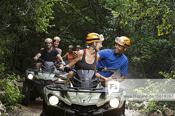 People riding quad bikes on Emotions Native Park dirt road  Quintana Roo  Mexico